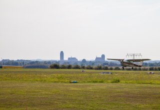 Flugzeug beim Start. Im Hintergrund die Silhouette von Wismar. // &copy; Frank Burger