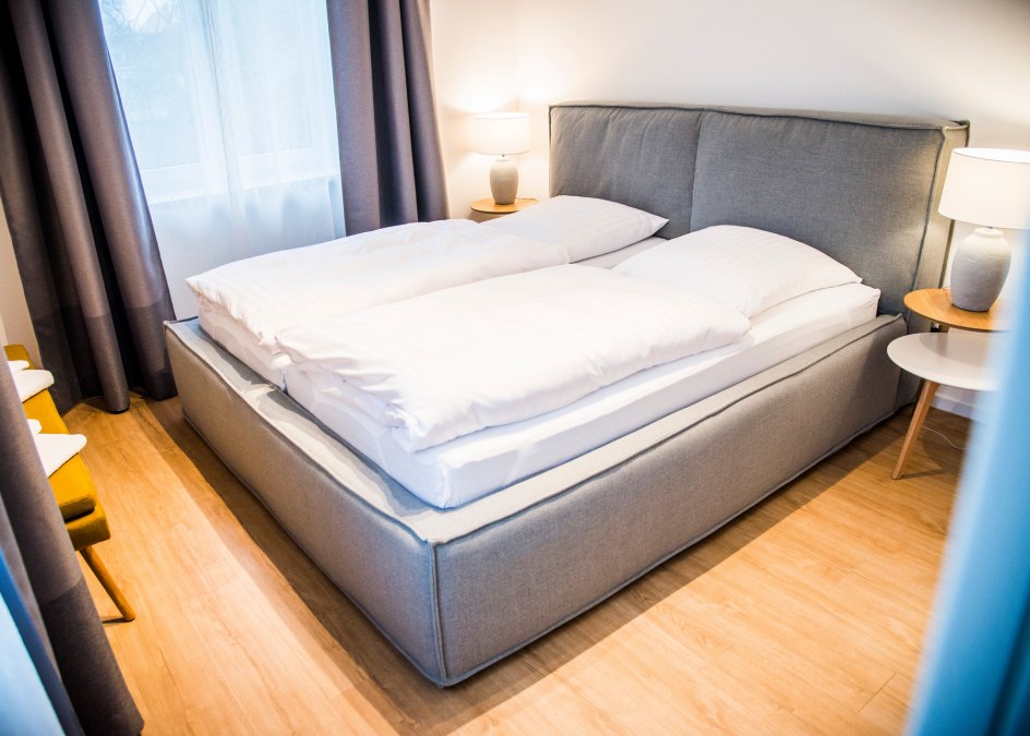 Een slaapkamer is ingericht met een tweepersoonsbed, de tweede met twee eenpersoonsbedden, © Lichthof Neubrandenburg