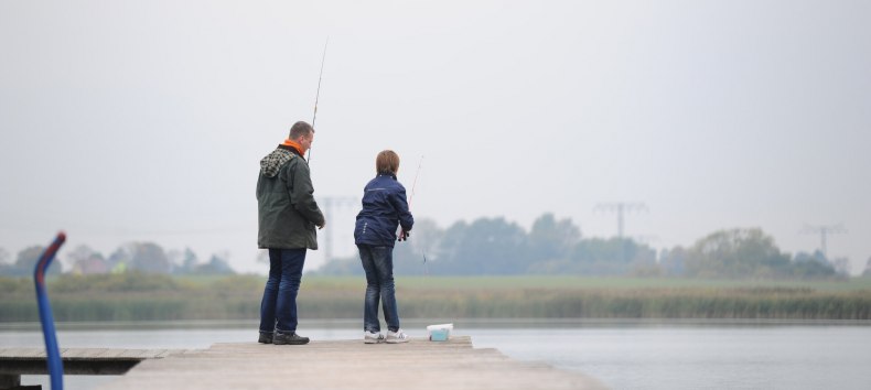 Ojciec i syn łowiący ryby na jeziorze Eixen w okręgu Pomorze Przednie-Rugia. // © MV-T/Foto@Andreas-Duerst.de Ojciec i syn łowiący ryby na jeziorze Eixen w okręgu Pomorze Przednie-Rugia. // © MV-T/Foto@Andreas-Duerst.de