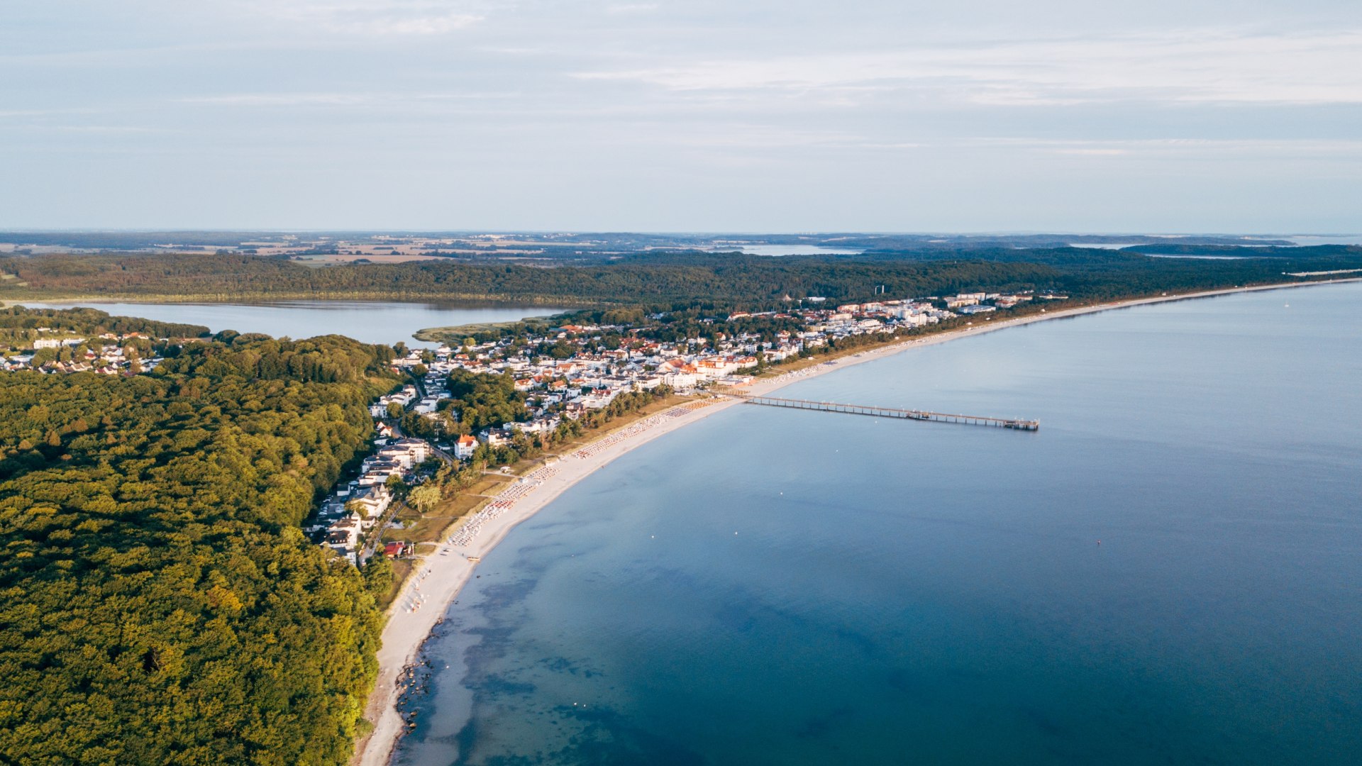 Luchtfoto van Binz op R&uuml;gen met pier, kustlijn en omliggende bossen.