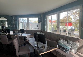 Helle Lounge-Ecke mit stilvollen Arbeitsplätzen und Blick ins Grüne. // © Michelle Dynio Helle Lounge-Ecke mit stilvollen Arbeitsplätzen und Blick ins Grüne. // © Michelle Dynio
