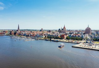Z g&oacute;ry port miejski w Rostocku wygląda jak miniaturowa kraina czar&oacute;w. Nawet diabelski młyn nagle nie wydaje się tak ogromny. Statek wycieczkowy spokojnie podjeżdża do nabrzeża, aby zabrać nowych pasażer&oacute;w. // &copy; MV-T/G&auml;nsicke