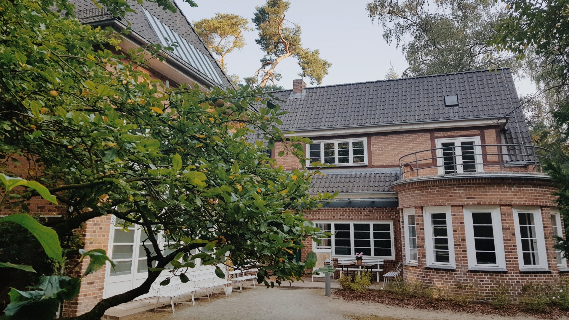 Het Ernst Barlach atelierhuis in Güstrow, © Christin Sobeck Het Ernst Barlach Atlelierhaus in Güstrow van de buitenkant met witte banken ervoor.