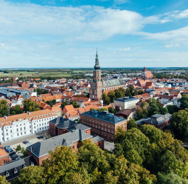 Het silhouet van Greifswald vanuit de lucht met overdag uitzicht op de kerktorens en het oude stadscentrum.