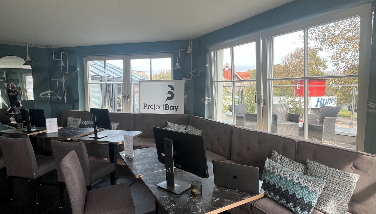 Jasny kącik wypoczynkowy ze stylowymi stanowiskami pracy i widokiem na zieleń., © Michelle Dynio Jasny kącik wypoczynkowy ze stylowymi stanowiskami pracy i widokiem na zieleń., © Michelle Dynio