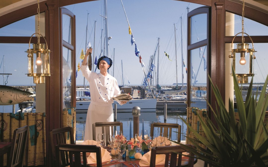 Geniet van je maaltijd in een stijlvolle ambiance met uitzicht op de Baltische Zee, waaronder Italiaanse pizza's en verse visgerechten., © Yachthafenresidenz Hohe Düne, www.hohe-düne.de