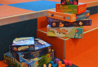 Viele verschiedene Gesellschaftsspiele wurden übereinandersgestapelt und Spielfiguren präsentiert. // © Stadtbibliothek Stralsund Viele verschiedene Gesellschaftsspiele wurden übereinandersgestapelt und Spielfiguren präsentiert. // © Stadtbibliothek Stralsund