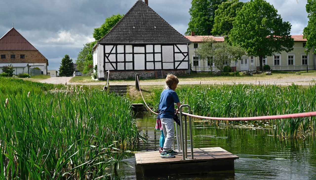 Over de vijver in Schlatkow Manor Park op een vlot, © WERK Gut WOHNEN Schlatkow