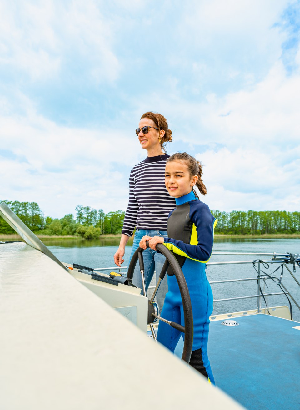 Een moeder en kind aan het stuur van een woonboot