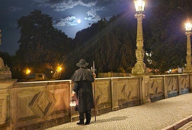 Night watchman on the bridge looking towards the castle at night., © Michael Kratt