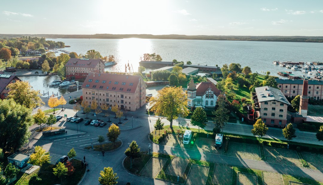 Widok z lotu ptaka na Neustrelitz z jeziorem w tle // W Neustrelitz kamper jest zaparkowany na boisku w porcie miejskim - blisko wody. // © MV-T/Gänsicke Widok z lotu ptaka na Neustrelitz z jeziorem w tle