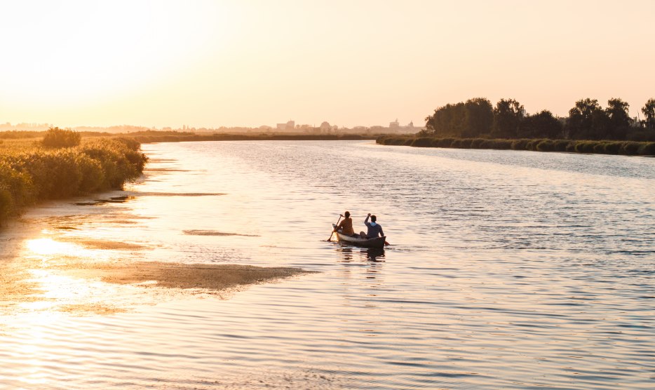 Een rustige avond op het water: twee mensen peddelen bij zonsondergang door de brede wateren van West-Pommeren, omringd door natuur en stilte.