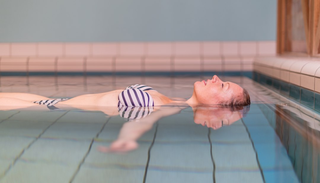 Kobieta relaksuje się w pływającym basenie z solanką termalną w centrum spa Waren