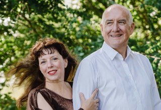 Authentisches Outdoor-Porträt zweier Personen in einer grünen Parklandschaft, ideal für Veranstaltungs- oder Künstlerseiten. // © duo-con-emonzione Authentisches Outdoor-Porträt zweier Personen in einer grünen Parklandschaft, ideal für Veranstaltungs- oder Künstlerseiten. // © duo-con-emonzione