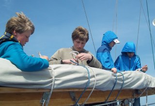 Young people on the chart house, packing the mainsail // © Mirko Niebuhr 2017 Young people on the chart house, packing the mainsail // © Mirko Niebuhr 2017