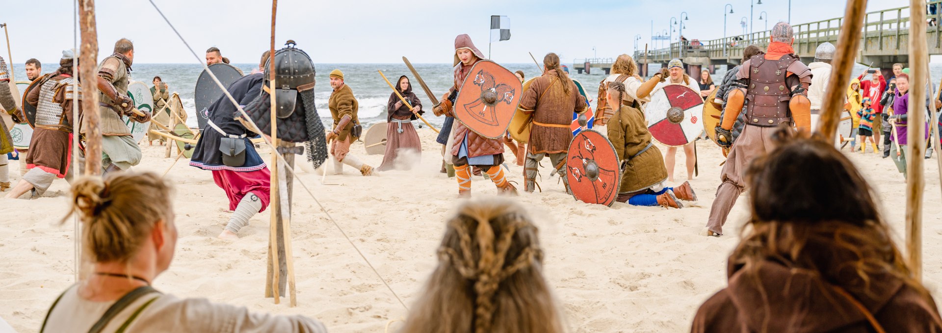 Een ge&euml;nsceneerd Vikinggevecht in G&ouml;hren met uitzicht over het strand naar de Oostzee naast de pier.