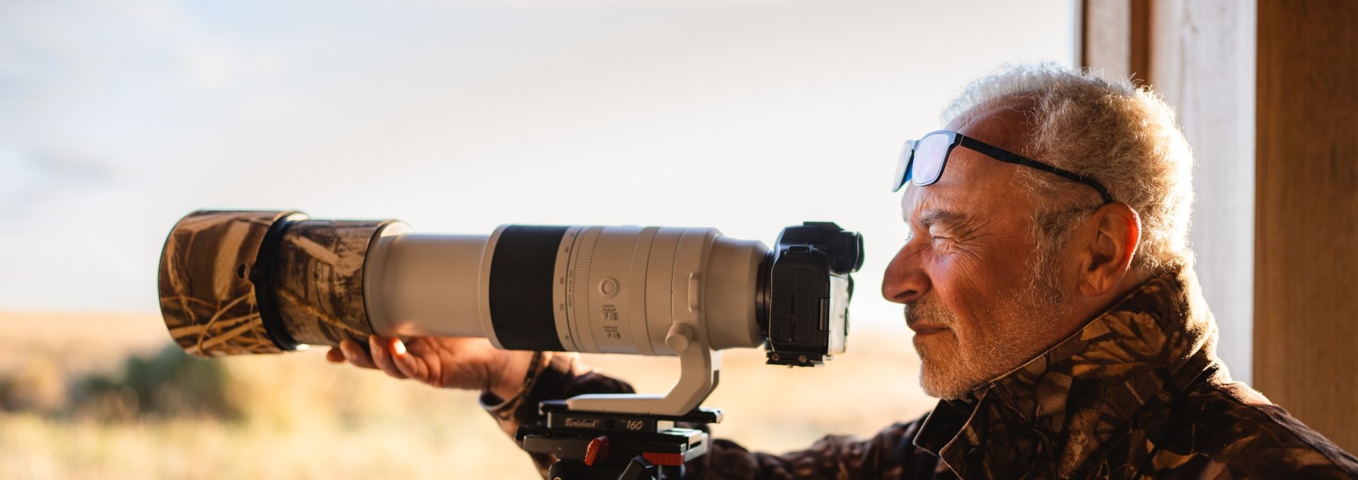 Een ervaren fotograaf met een telelens observeert de wilde dieren in het Vorpommersche Boddenlandschaft National Park.