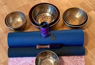 Setup für eine heilsame Auszeit: Traditionelle Klangschalen und sanfte Klangspiele stehen auf blauen Yogamatten bereit für die nächste meditative Chakren-Klangreise. Vorbereitung für tiefe Entspannung und Harmonisierung der Energiezentren. // © Sandra Dethier Setup für eine heilsame Auszeit: Traditionelle Klangschalen und sanfte Klangspiele stehen auf blauen Yogamatten bereit für die nächste meditative Chakren-Klangreise. Vorbereitung für tiefe Entspannung und Harmonisierung der Energiezentren. // © Sandra Dethier