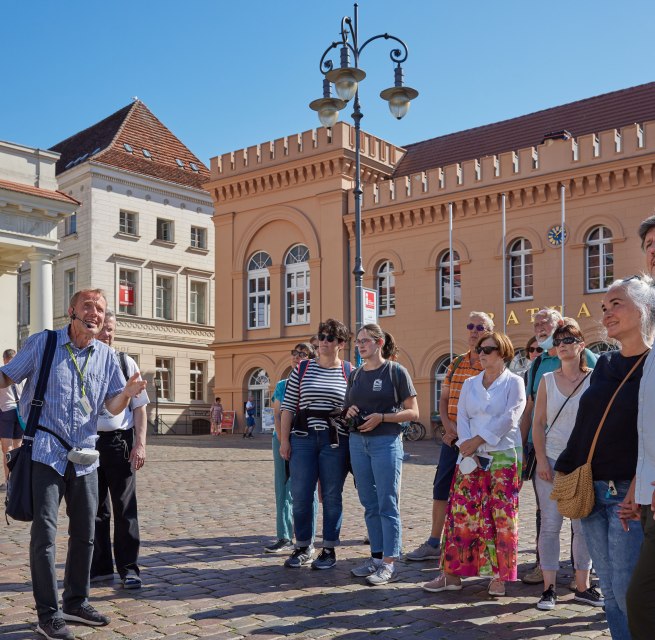 Stadsgids met een groep gasten op de markt van Schwerin voor het stadhuis. // © Oliver Borchert Stadsgids met een groep gasten op de markt van Schwerin voor het stadhuis. // © Oliver Borchert