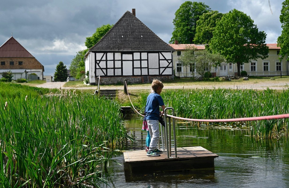 Over de vijver in Schlatkow Manor Park op een vlot, © WERK Gut WOHNEN Schlatkow Over de vijver in Schlatkow Manor Park op een vlot, © WERK Gut WOHNEN Schlatkow