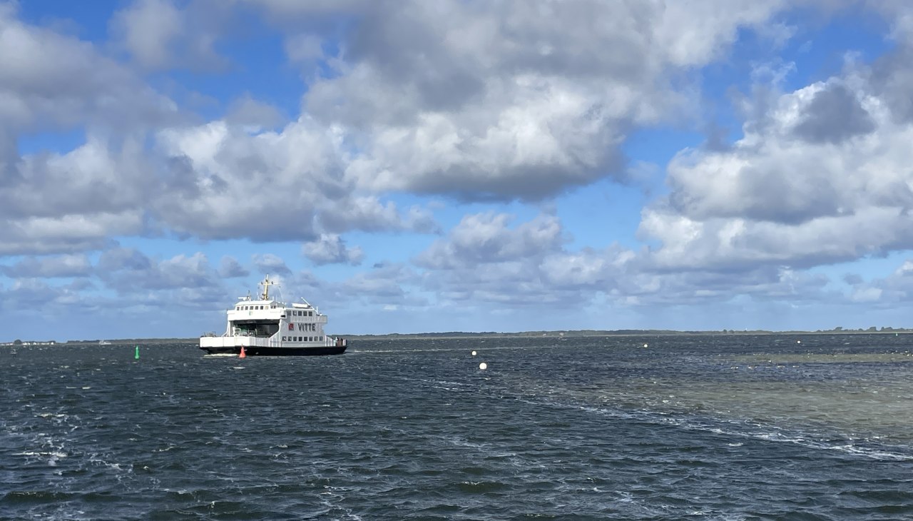 De veerboot vaart op open water; blauwe lucht met witte wolken, © Anja Heitmüller De veerboot vaart op open water; blauwe lucht met witte wolken, © Anja Heitmüller
