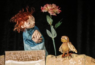 Bild einer Szene aus dem Stück mit der kleinen Frau, einer Blume und einem Vogel // © Klaus Schiebold Bild einer Szene aus dem Stück mit der kleinen Frau, einer Blume und einem Vogel // © Klaus Schiebold