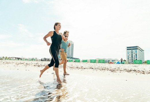 Een atleet rent op het strand in Warnemünde in de zomer