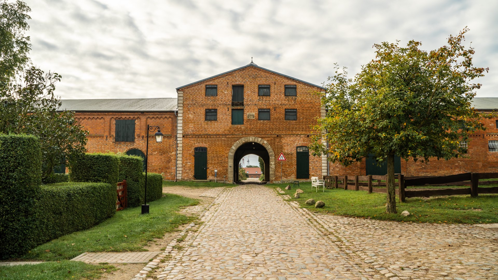 The entrance gate to the Dalwitz estate made of bricks and a paved path.