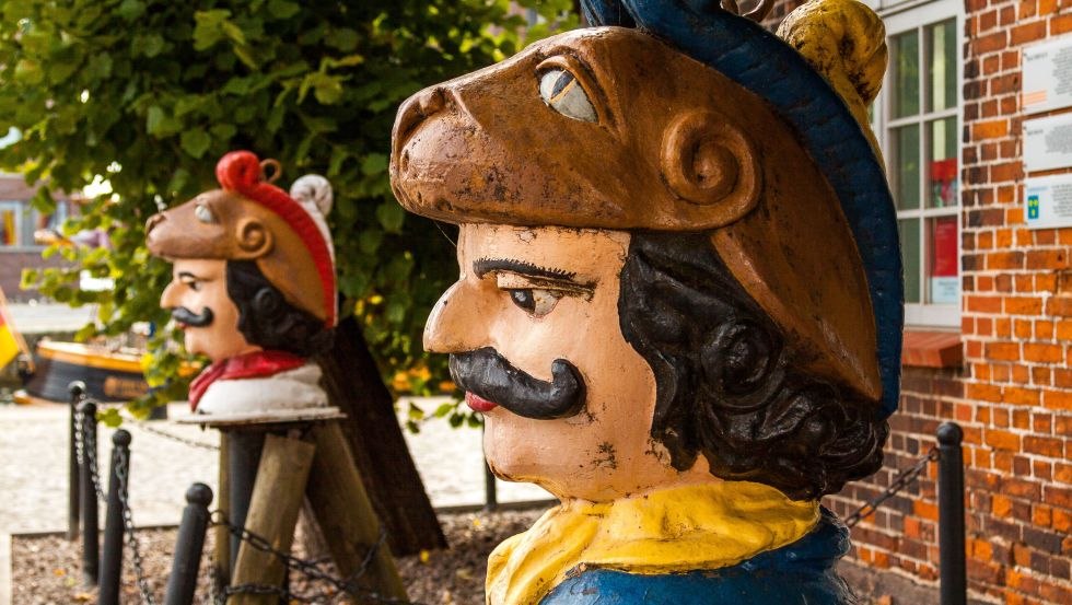 Szwedzkie głowy przed domkiem na drzewie // &copy; TZ Wismar, A. Rudolph