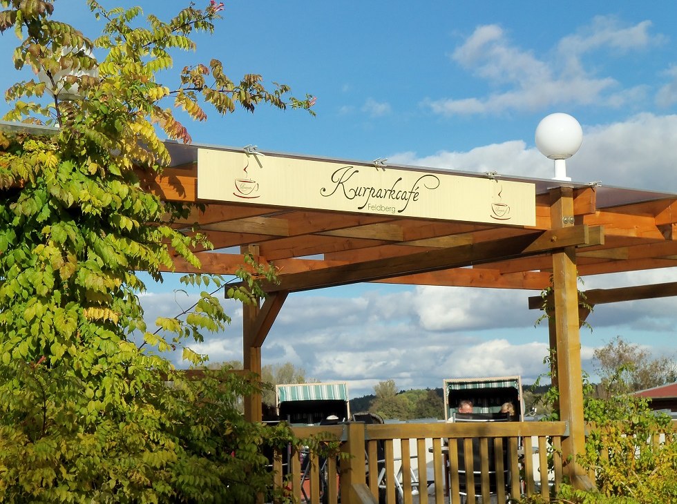 Widok z ulicy na logo kawiarni z leżakami plażowymi w tle, © Tortenmarie Photo Widok z ulicy na logo kawiarni z leżakami plażowymi w tle, © Tortenmarie Photo