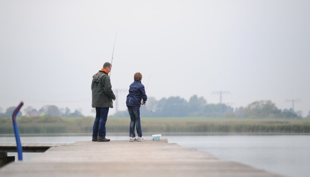 Ojciec i syn łowiący ryby na jeziorze Eixen w okręgu Pomorze Przednie-Rugia. // © MV-T/Foto@Andreas-Duerst.de Ojciec i syn łowiący ryby na jeziorze Eixen w okręgu Pomorze Przednie-Rugia. // © MV-T/Foto@Andreas-Duerst.de