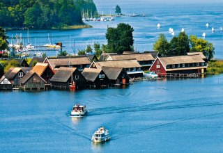 Embedded in a beautiful forest and lake landscape, the R&ouml;bel Bay appears with its small fishing cottages and sailboats. // &copy; MV-T/Kuhnle Tours