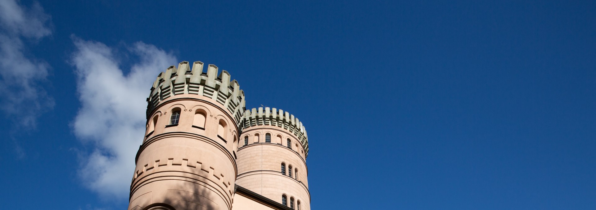 Granitz hunting lodge on Rügen with round towers and battlements against a blue sky.