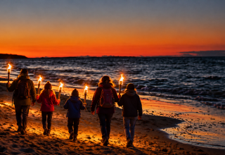&copy; Familienwanderung im Fackelschein am Strand.png