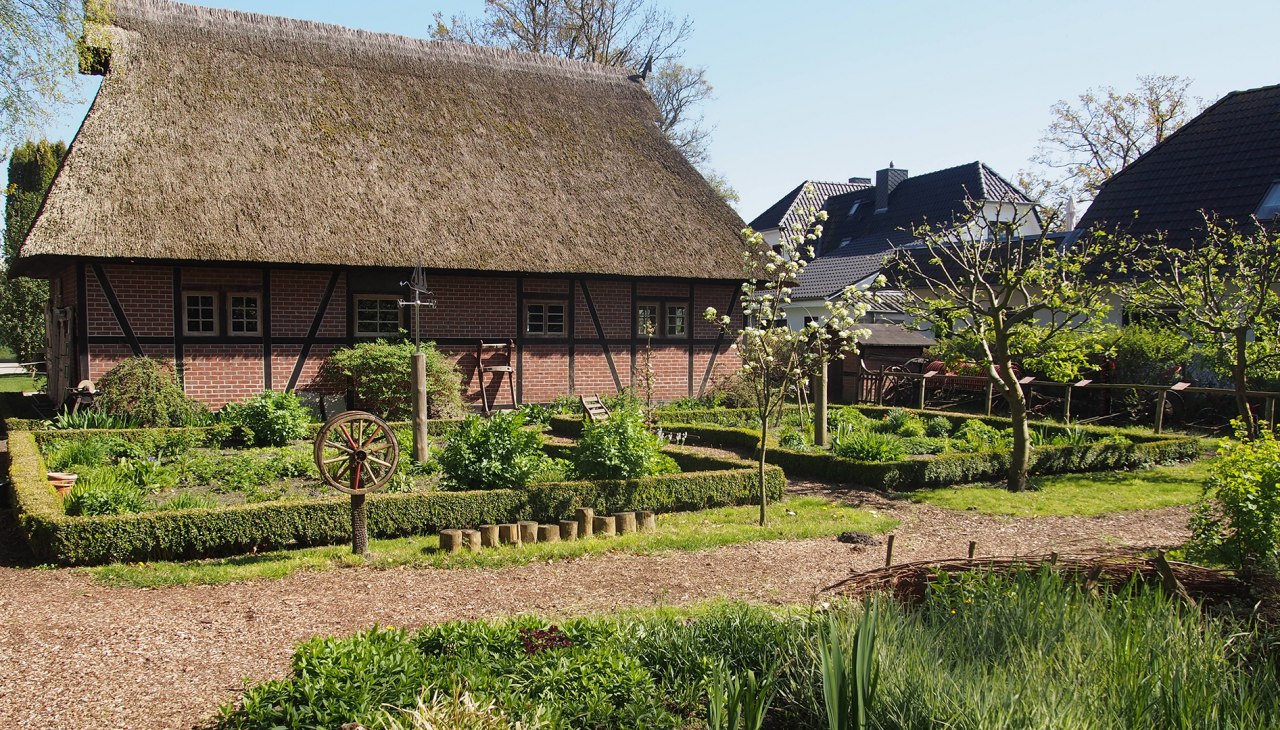 Op de boerderij, enigszins verborgen achter de schuur: de kleine boerderijtuin met oude landbouwmachines., © Kur- und Tourismus GmbH Zingst