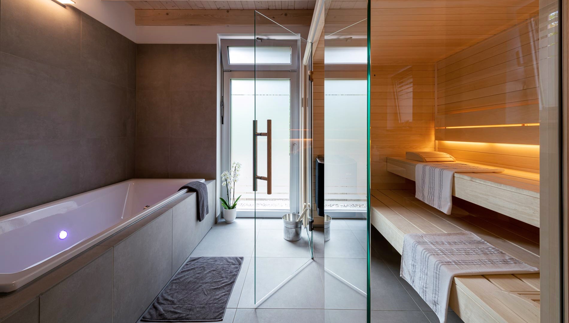 Een sauna en bad in de badkamer van het vakantiehuis
