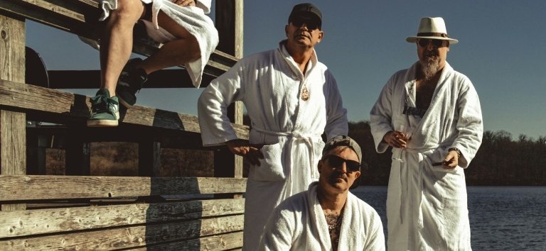 four musicians from the band Herb in white bathrobes on a bathing platform // &copy; Herb Band