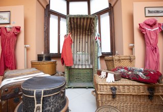 Zabytkowe krzesło plażowe z XIX-wiecznym strojem kąpielowym i bagażem. // © Stadt- und Bädermuseum Bad Doberan Zabytkowe krzesło plażowe z XIX-wiecznym strojem kąpielowym i bagażem. // © Stadt- und Bädermuseum Bad Doberan