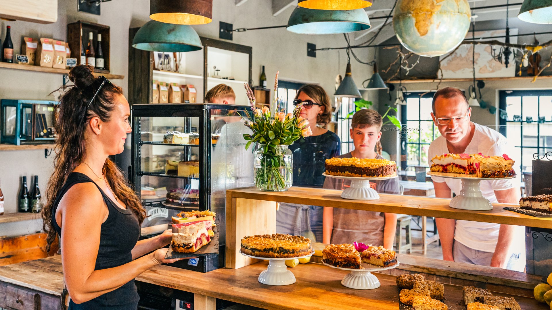 Café Gnitzer Seelchen - een familie staat aan de toonbank met een taartenbuffet.