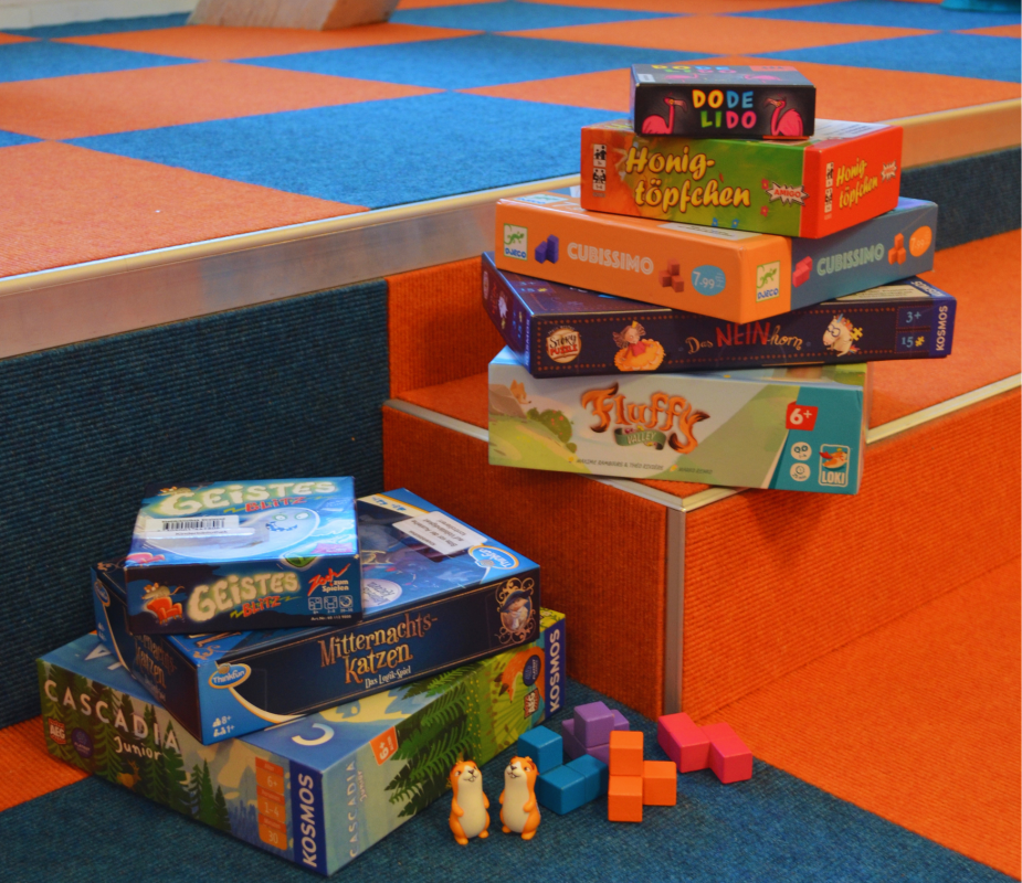 Many different board games were stacked on top of each other, and game pieces were displayed. // © Stadtbibliothek Stralsund Many different board games were stacked on top of each other, and game pieces were displayed. // © Stadtbibliothek Stralsund