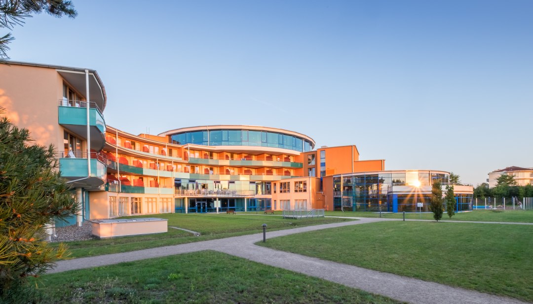 Het Waren spa centrum van buiten bij zonsondergang // Het kuuroord Waren van buiten // © Kurzentrum Waren Het Waren spa centrum van buiten bij zonsondergang