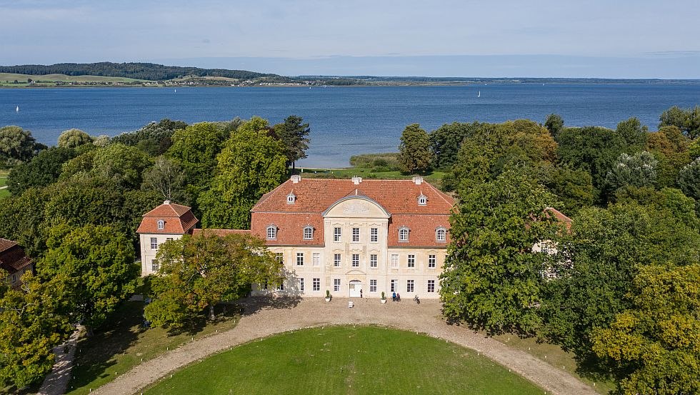 Luchtfoto's van Kasteel Kumerow, het blauwe meer glinstert op de achtergrond, © Tourismusverband Mecklenburgische Seenplatte/Tobias Kramer