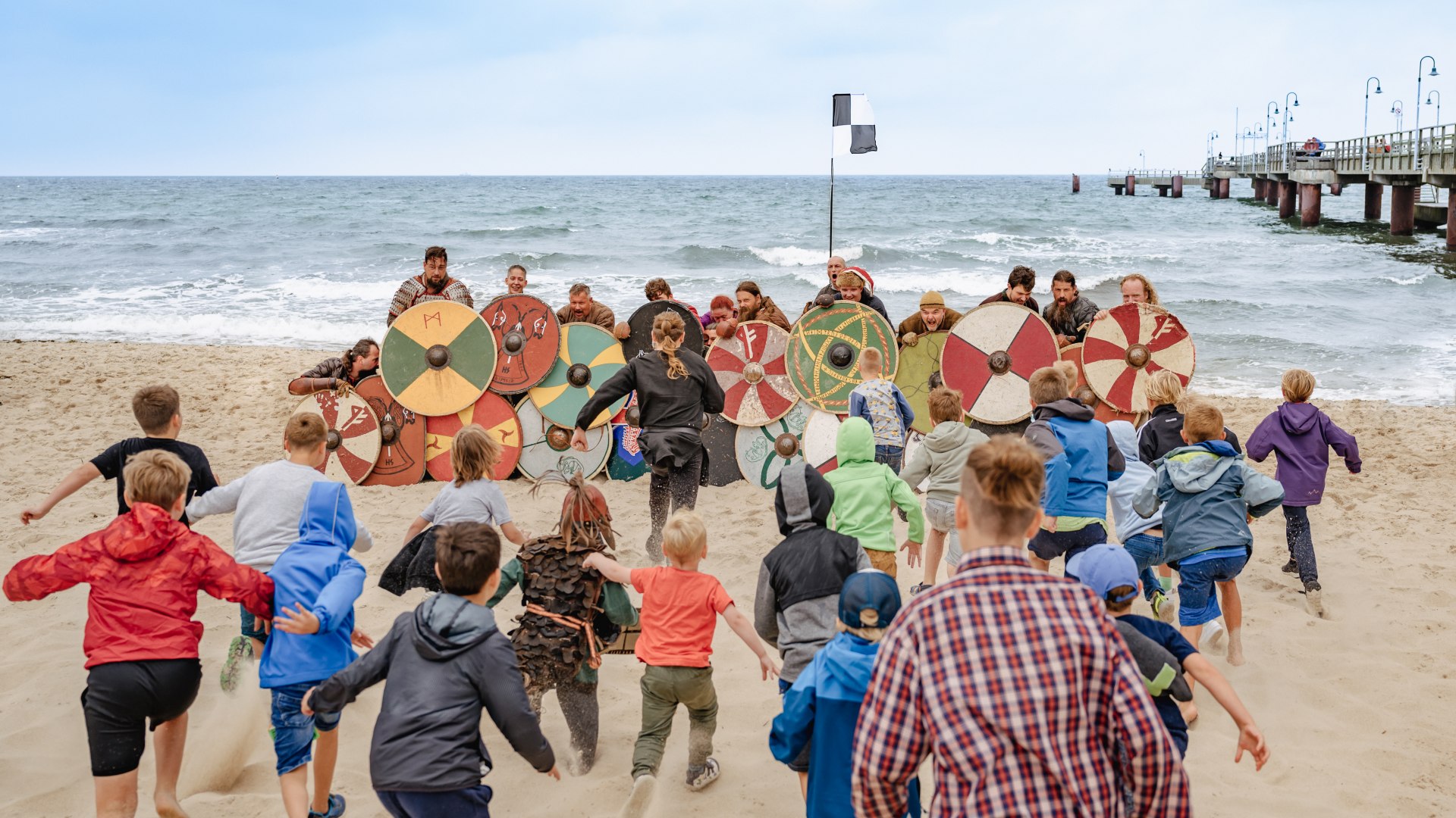 Ściana znaków przeciwko atakowaniu dzieci na plaży - festiwal wikingów w Göhren. // Wielki finał: Kiedy dzieci z Göhren atakują, nawet hordy wikingów zostają pokonane. // © MV-T/Tiemann Ściana znaków przeciwko atakowaniu dzieci na plaży - festiwal wikingów w Göhren.