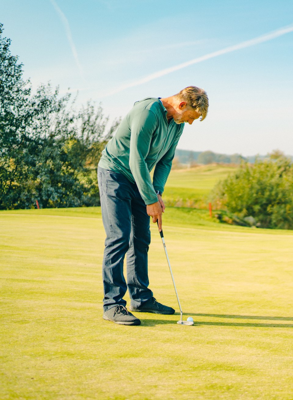 Golfiści stawiający na green w Ostsee-Golf-Resort Wittenbeck z widokiem na krajobraz.