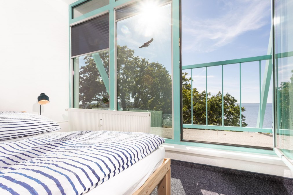 Bright bedroom with a view of the Bodden, perfect for relaxing after a productive day at work., © Project Bay