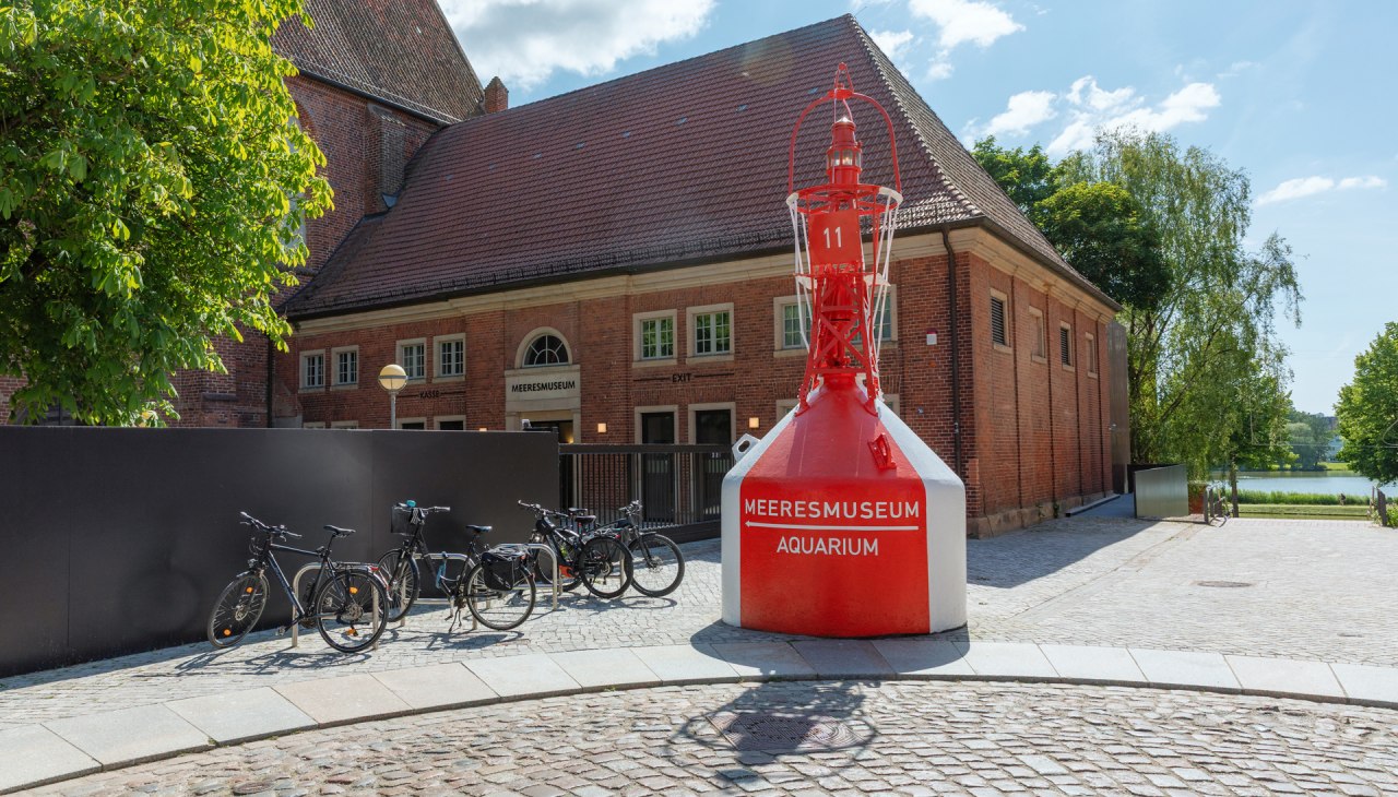 A red and white striped barrel, which once served as a navigation sign, stands at the accessible Bielkenhagen entrance., © Anke Neumeister/Deutsches Meeresmuseum