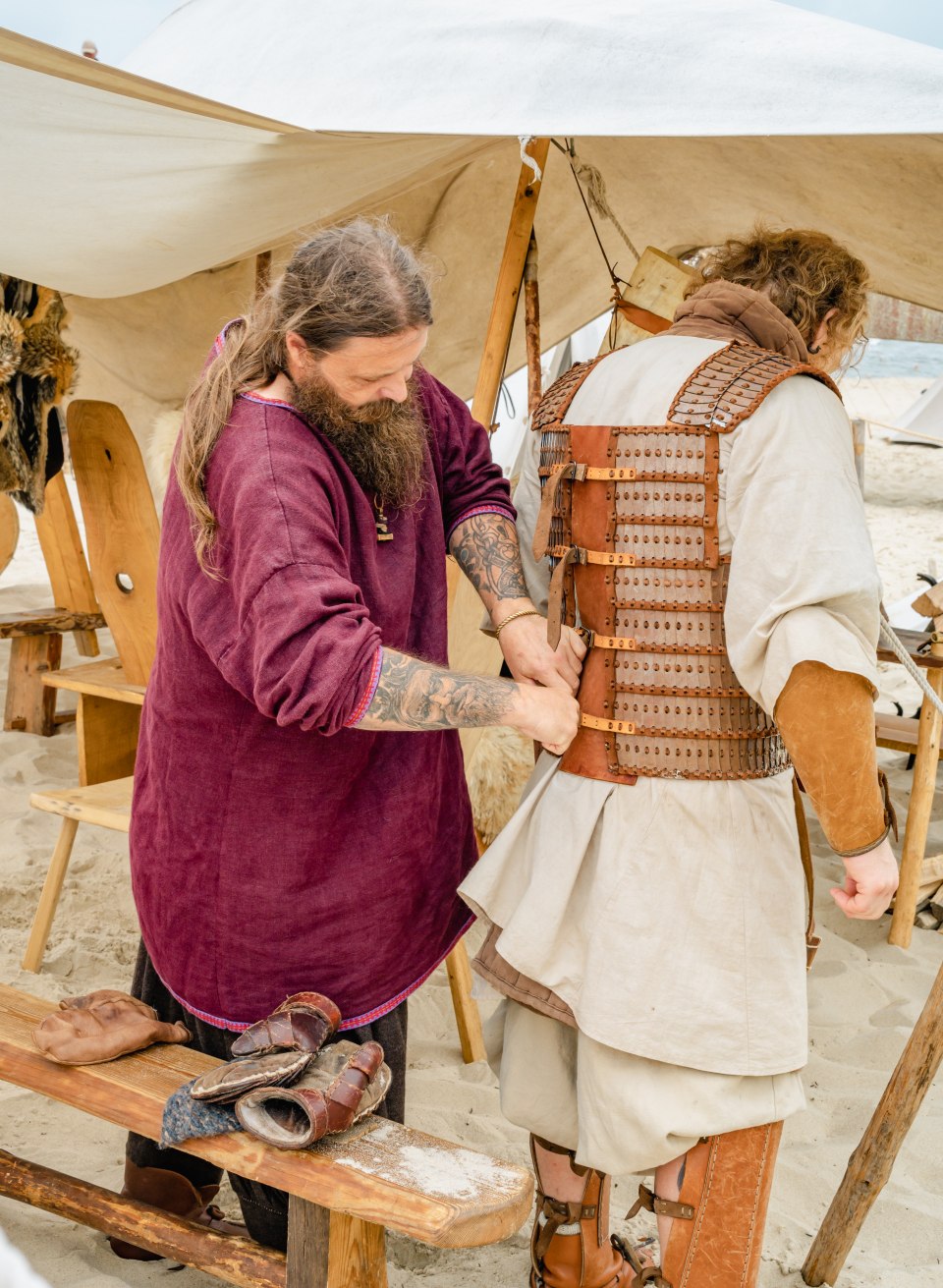 De gewaden van de strijders wegen tot twintig kilo, dus het kan even duren om ze aan te trekken met de hulp van je eigen clan., © TMV/Tiemann Een Vikingkostuum met harnas aantrekken op het Vikingfestival in Göhren.