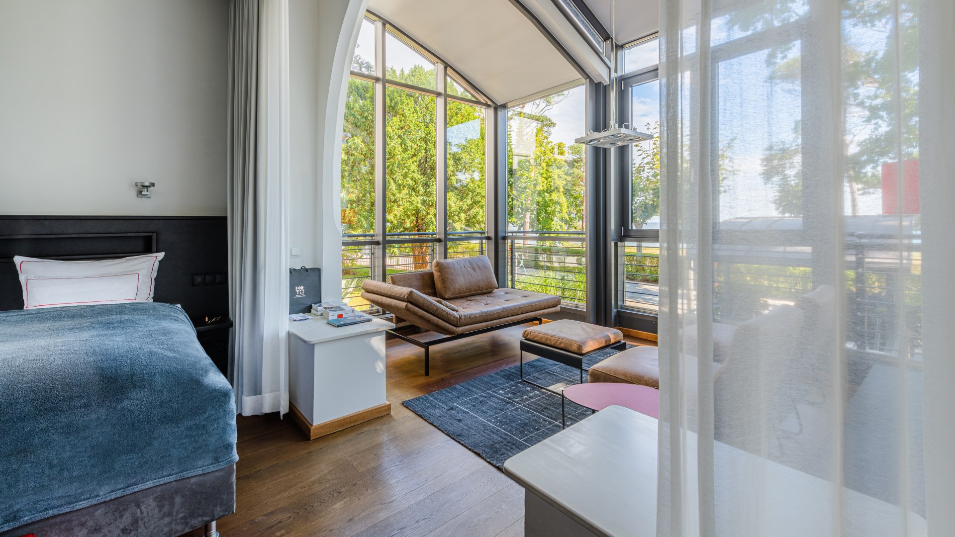 Wolfgang Schewe heeft altijd oog gehad voor mooie materialen en ruimtes: kamers in Hotel am Meer in Binz, © TMV/Tiemann Een kamer van binnen in Hotel am Meer in Binz - bed, zitgedeelte met uitzicht op de promenade