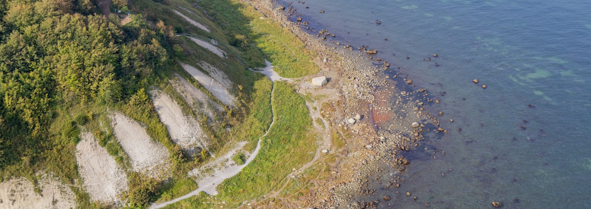 Luchtfoto van de kust bij Kaap Arkona met steile krijtrotsen, groene vegetatie en helder water uit de Baltische Zee.