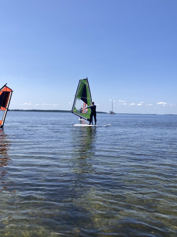 Windsurfing course for beginners on the Salzhaff in Rerik: participants learn the basics in shallow water under the guidance of the Rerik surf school. The standing area offers ideal conditions for a safe and quick introduction to windsurfing on the Baltic Sea. // © Henning Schult Windsurfing course for beginners on the Salzhaff in Rerik: participants learn the basics in shallow water under the guidance of the Rerik surf school. The standing area offers ideal conditions for a safe and quick introduction to windsurfing on the Baltic Sea. // © Henning Schult